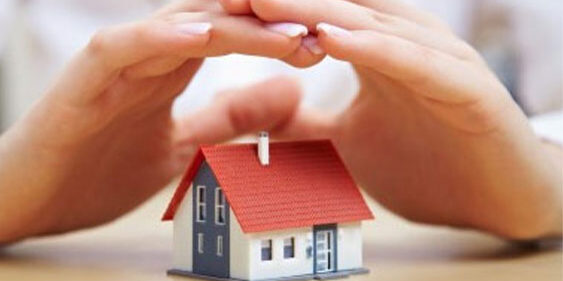 hands covering a miniature house